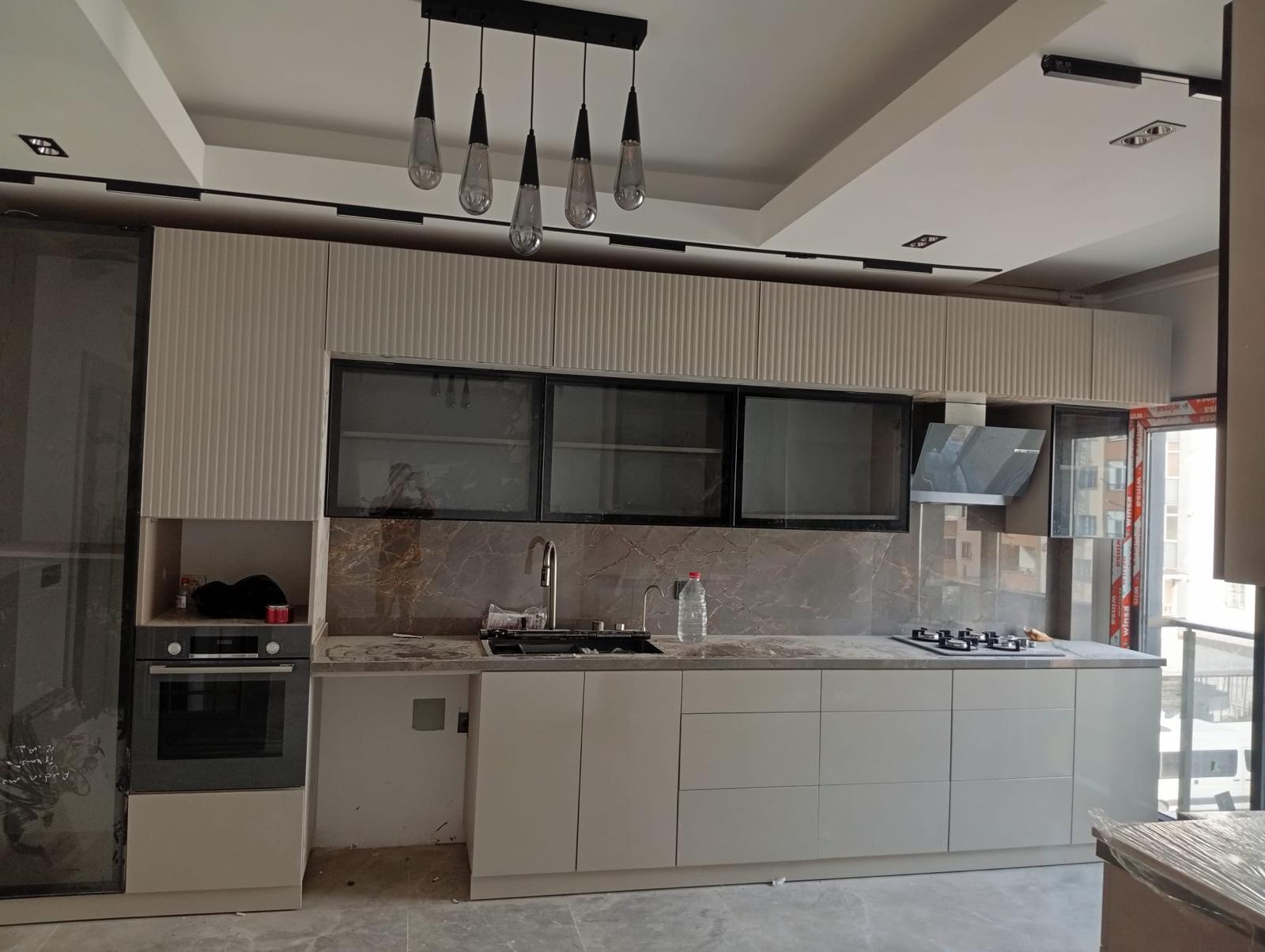 Taş desenli tezgâh ve açık renk dolaplarla mutfak yenileme çalışması